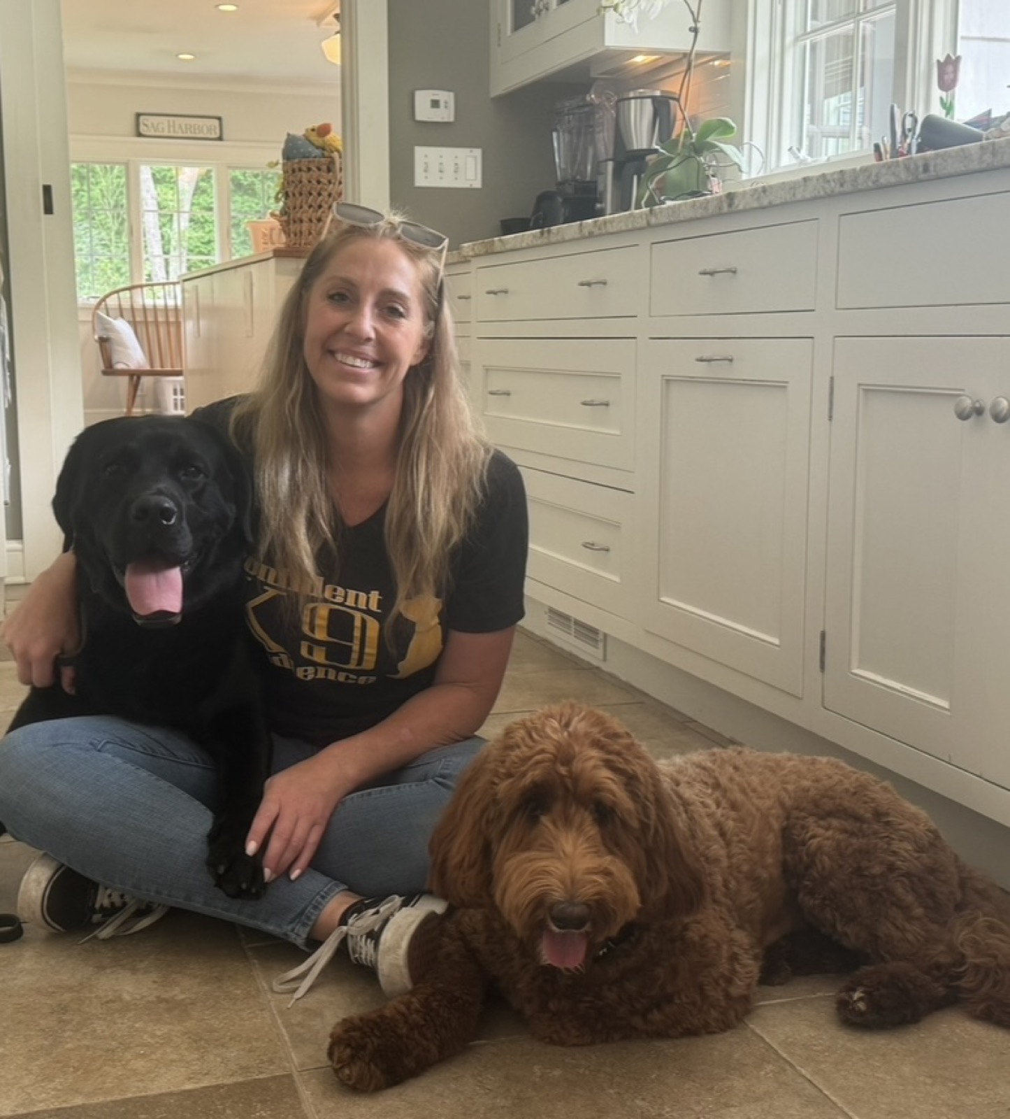 Dog trainer Kiley Kelly with a black lab and goldendoodle during a private training session